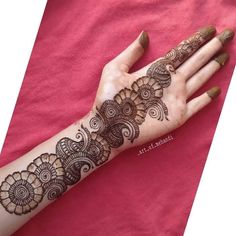 a woman's hand with henna tattoos on it