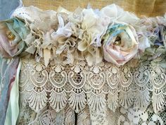 an old lace curtain is adorned with flowers