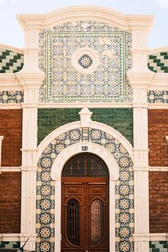 the front door to an old building with decorative tiles on it