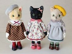 three stuffed animals dressed in clothes and hats