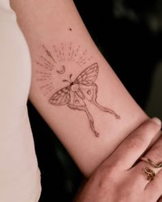 a woman's arm with a butterfly tattoo on the left side of her arm