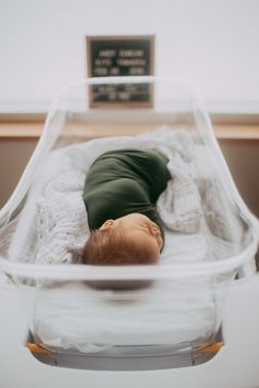 a baby is laying down in a clear crib