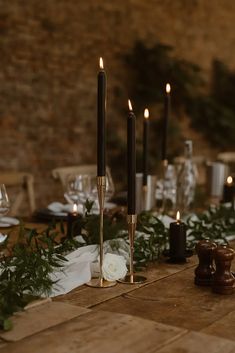 the table is set with candles and greenery