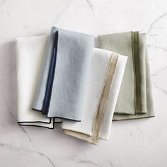 four folded napkins sitting on top of a white countertop next to each other