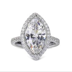 a pear shaped diamond ring set in 18k white gold with pave diamonds around the band