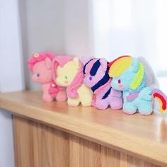 a row of stuffed animals sitting on top of a wooden counter