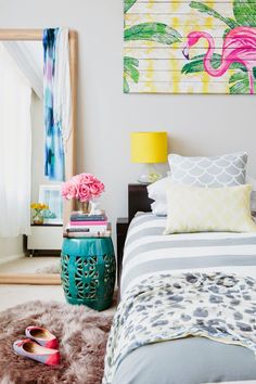 a bedroom with a bed, nightstand and colorful paintings on the wall above it's headboard