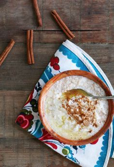 a bowl filled with oatmeal and cinnamon on top of a blue and white napkin