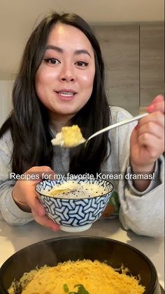 a woman eating food from a bowl with chopsticks in front of her face