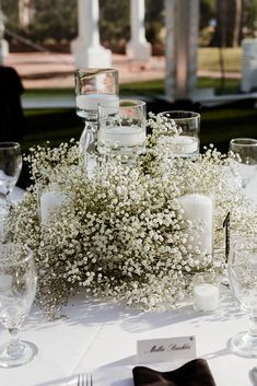 the table is set with white flowers and candles