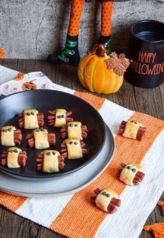 halloween treats made to look like pigs in a blanket are on a plate with candy