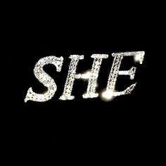 the word she written in white glitter on a black background