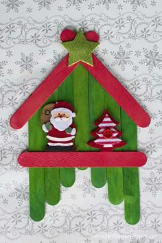 a christmas decoration made out of popsicle sticks with santa clause on top and trees