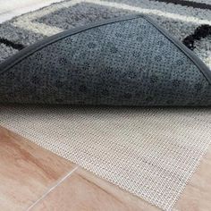 a black and white rug on the floor next to a cat scratch mat with an area rug underneath it