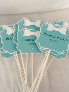 four blue and white wedding cake toppers with bow ties on them