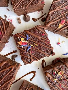 chocolate brownies drizzled with icing and sprinkles on a white surface