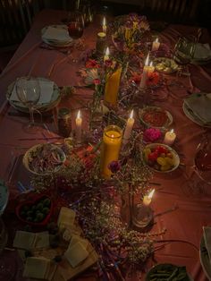 the table is set with candles, plates and other food items for an elegant dinner