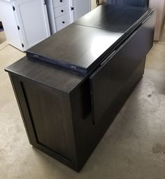 an empty kitchen with black counter tops and white cupboards in the backround