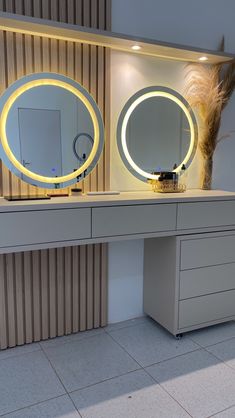 two round mirrors sitting on top of a white dresser