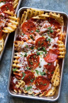 two pans filled with cheesy pizza and waffles covered in cheese