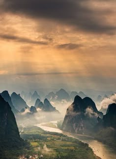 an aerial view of mountains, rivers and clouds