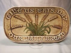 a plaque with wheat on it that says, give us this day our daily bread