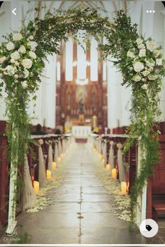 an aisle decorated with white flowers and greenery for a wedding at st mary's church