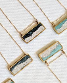 four necklaces with different designs on them