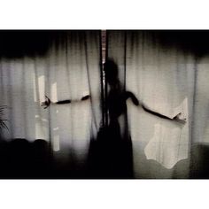 a blurry image of a person standing in front of a curtain