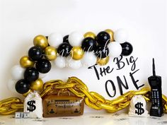 balloons and streamers are arranged in front of a backdrop with the words, the big one