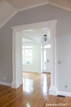 an empty room with hard wood floors and white trim