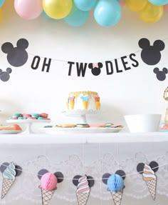 an ice cream themed birthday party with mickey mouse balloons and cake on a long table