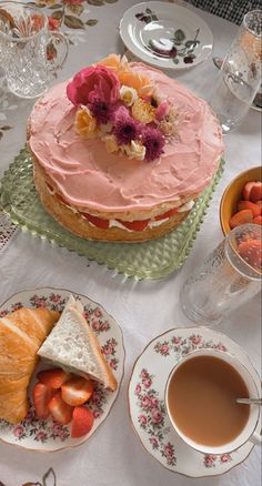 there is a cake on the table with tea cups and saucers next to it