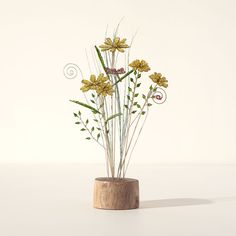 a wooden vase filled with yellow flowers on top of a table