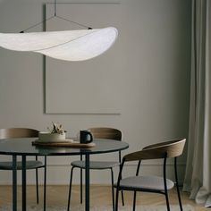 a dining room table with chairs and a light hanging over it