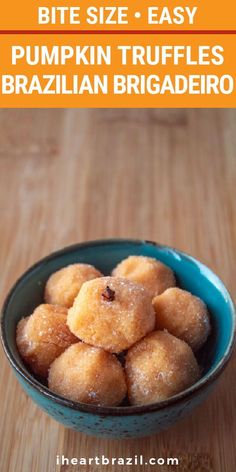 a blue bowl filled with sugared pumpkin truffles on top of a wooden table