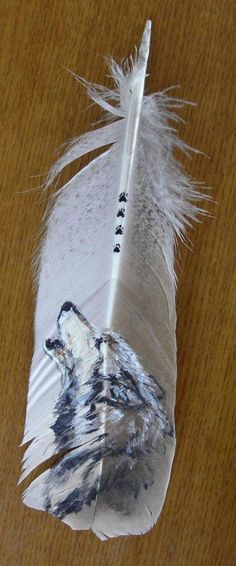 a white feather with a wolf head on it and a pen sticking out of it