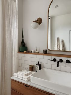 a bathroom with a sink, mirror and shower curtain