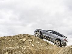 a car is driving on top of a pile of dirt