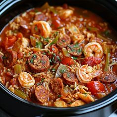 a close up of a bowl of food with shrimp and sausage