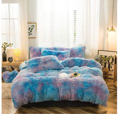 a bed covered in blue and pink fluffy fur