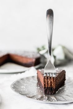 a piece of chocolate cake on a plate with a fork sticking out of the top