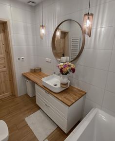 a bathroom with a sink, mirror and bathtub next to a wooden counter top