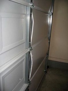 an open door in the middle of a room with metal bars on it's sides