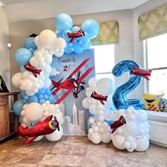 an air plane balloon arch with balloons in the shape of numbers 2 and two airplanes