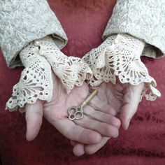 two hands holding an old pair of scissors with lace on them, and the words vannet above it