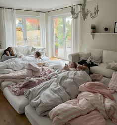 three children laying in bed with pink and white comforters on top of the sheets