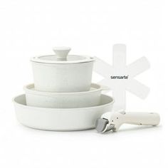 three white bowls and a hair dryer on a white background