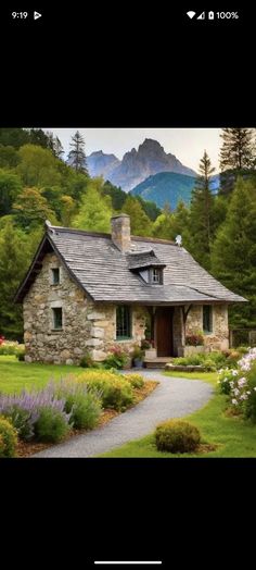 an image of a house in the middle of some flowers and trees with mountains in the background