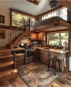 a kitchen with wooden floors and stairs leading up to the second floor, next to a stove top oven